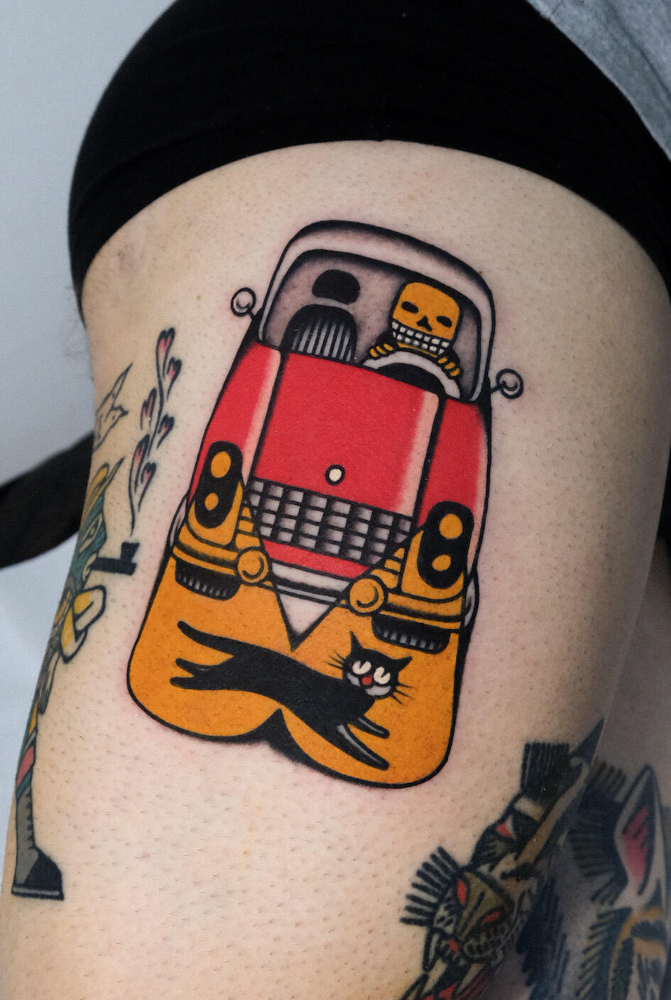 The skeleton driver and the unlucky black cat, color traditional tattoo made in Amsterdam.