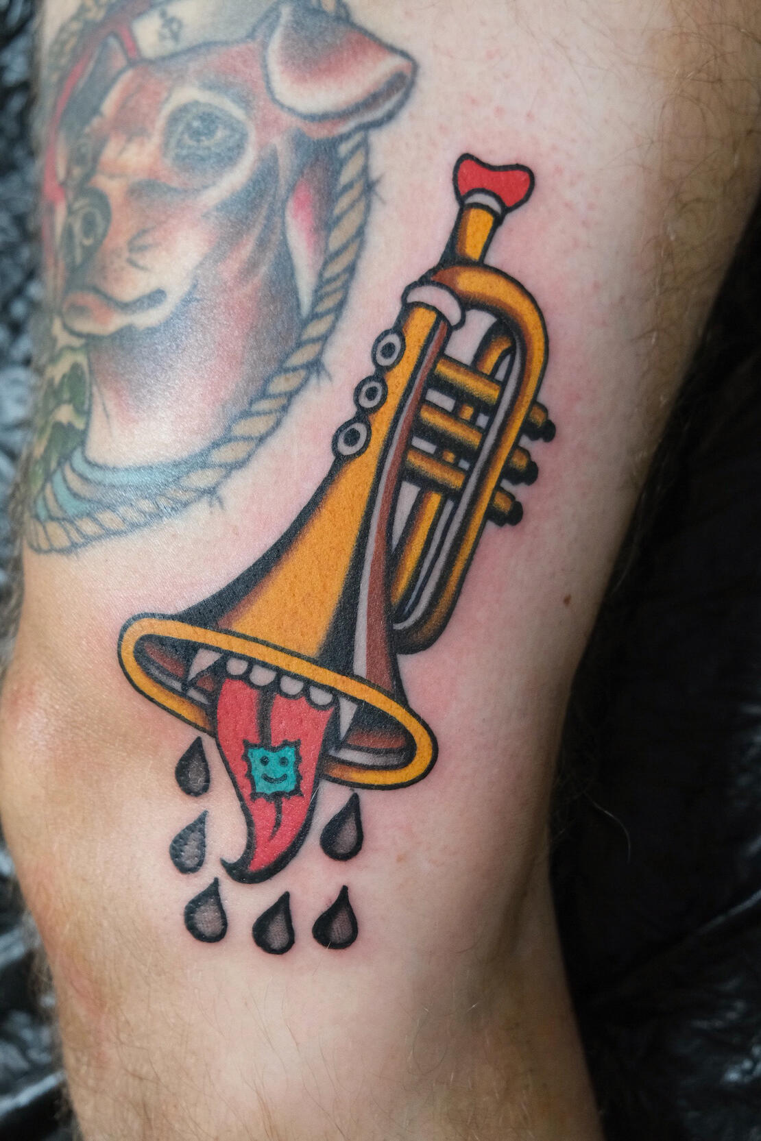 Golden trumpet with mouth and tongue, traditional color tattoo done in Amsterdam